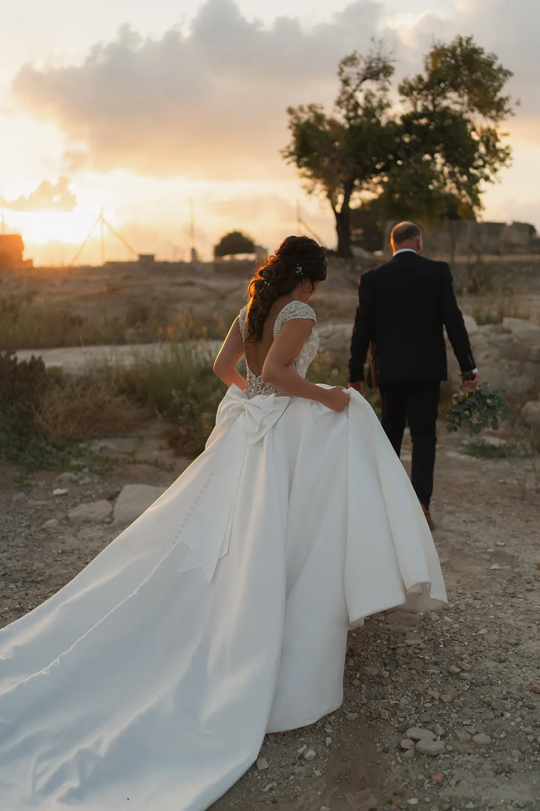 Couple walking at sunset with dramatic sky — Cyprus wedding
