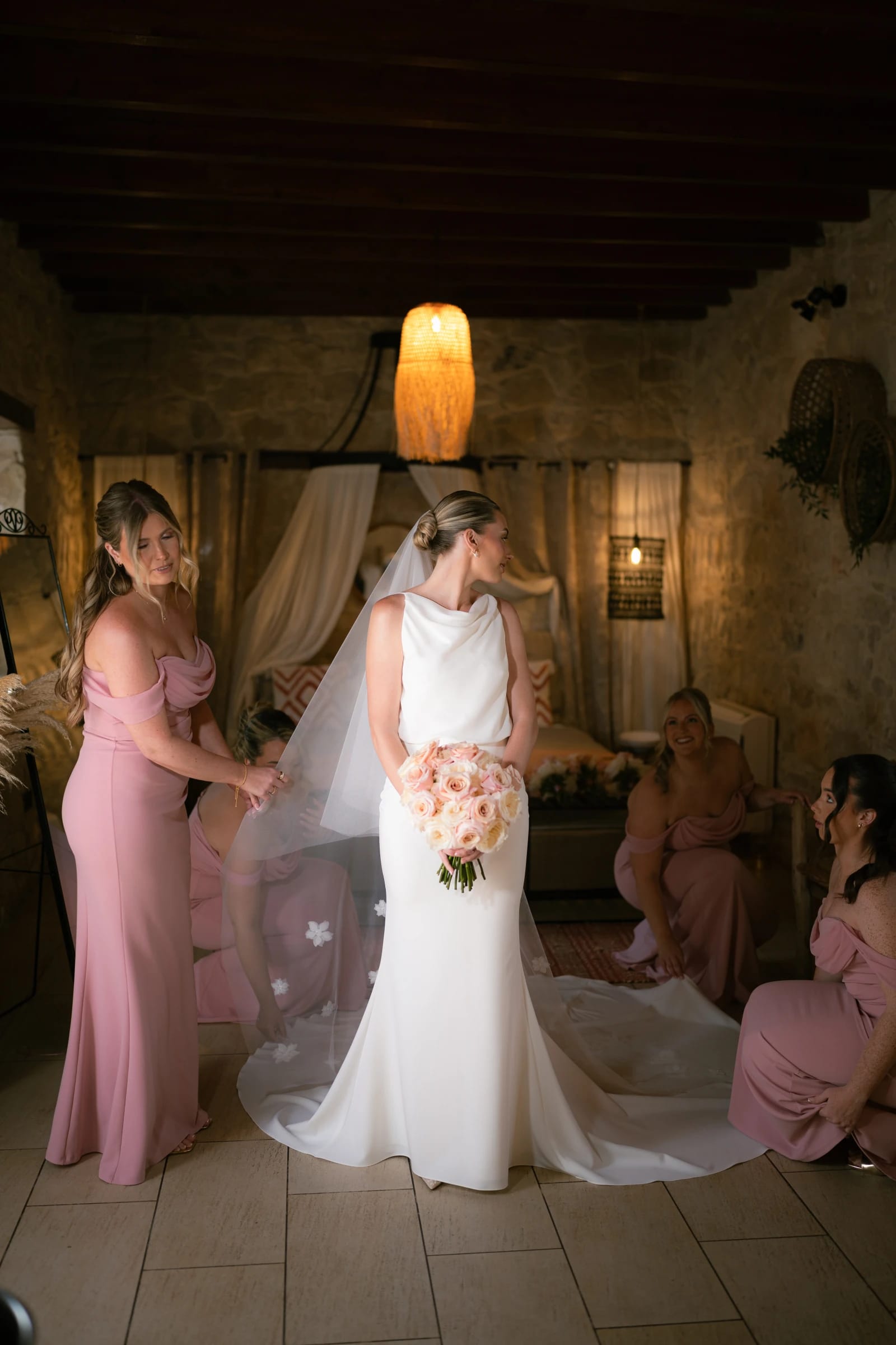 Bridesmaids helping Bailey into her wedding dress at Liopetro, Paphos, Cyprus.