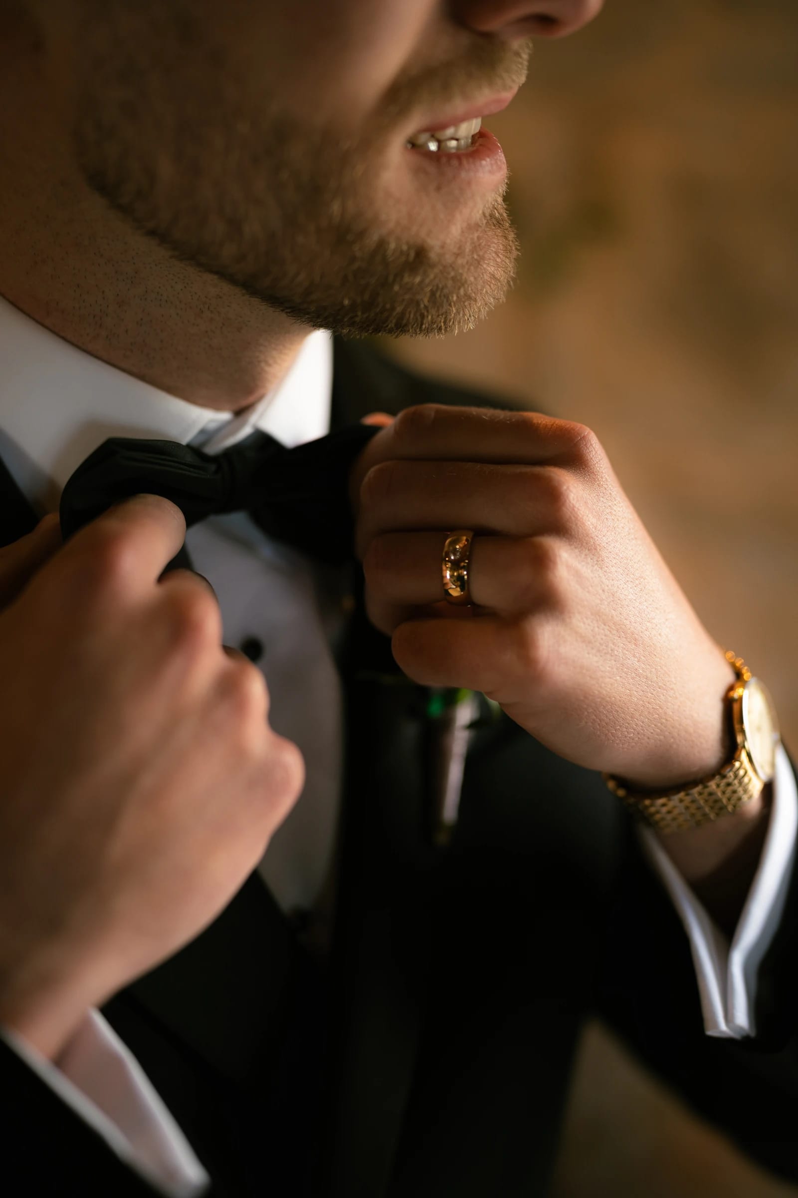 Black and white close-up of the groom adjusting his bow tie at Liopetro, Kouklia, Paphos.