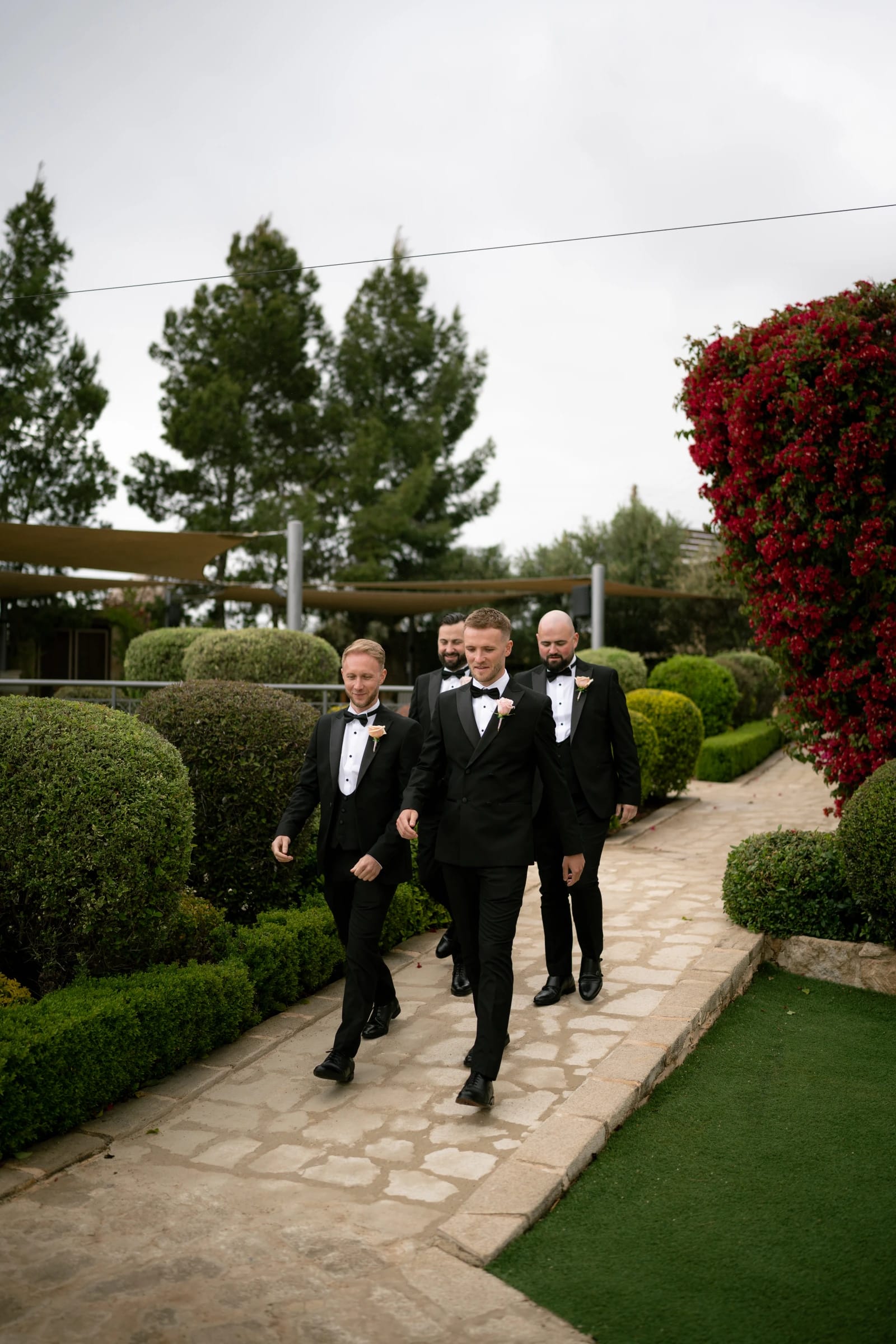 Groom and groomsmen walking the stone path to the ceremony at Liopetro, Kouklia, Paphos.