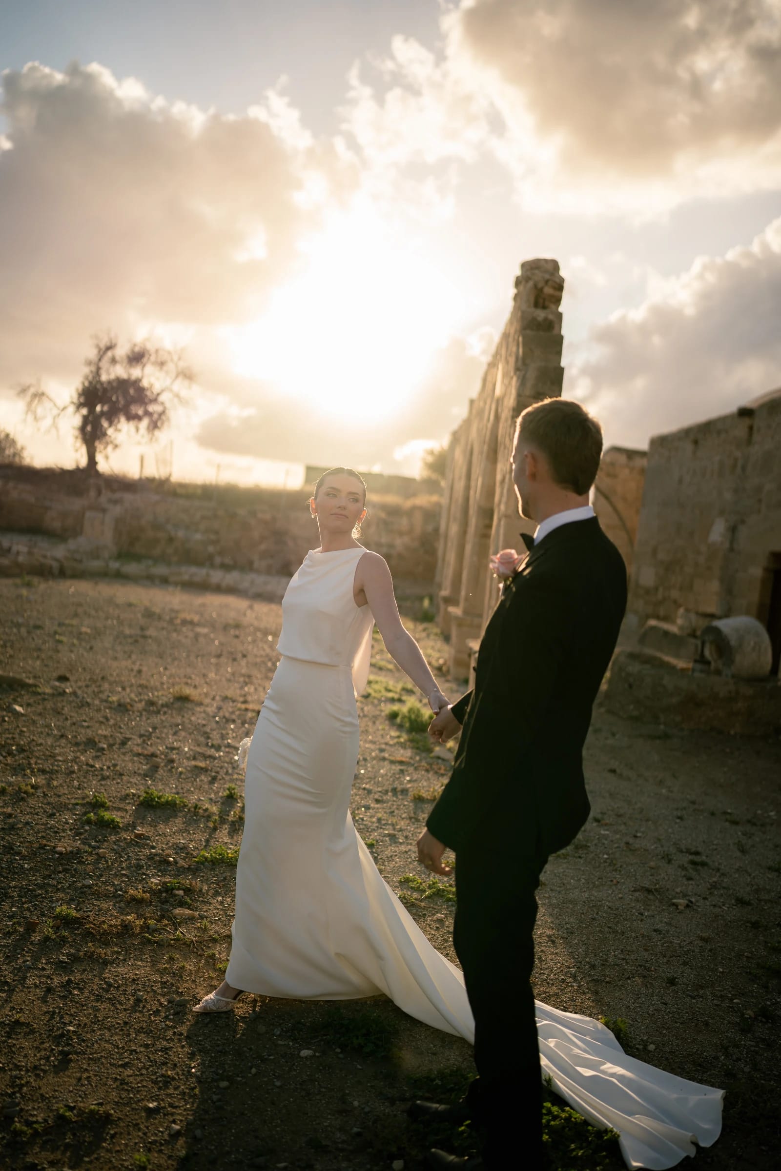 Daniel and Bailey holding hands silhouetted against the Cyprus sunset at Liopetro, Paphos.