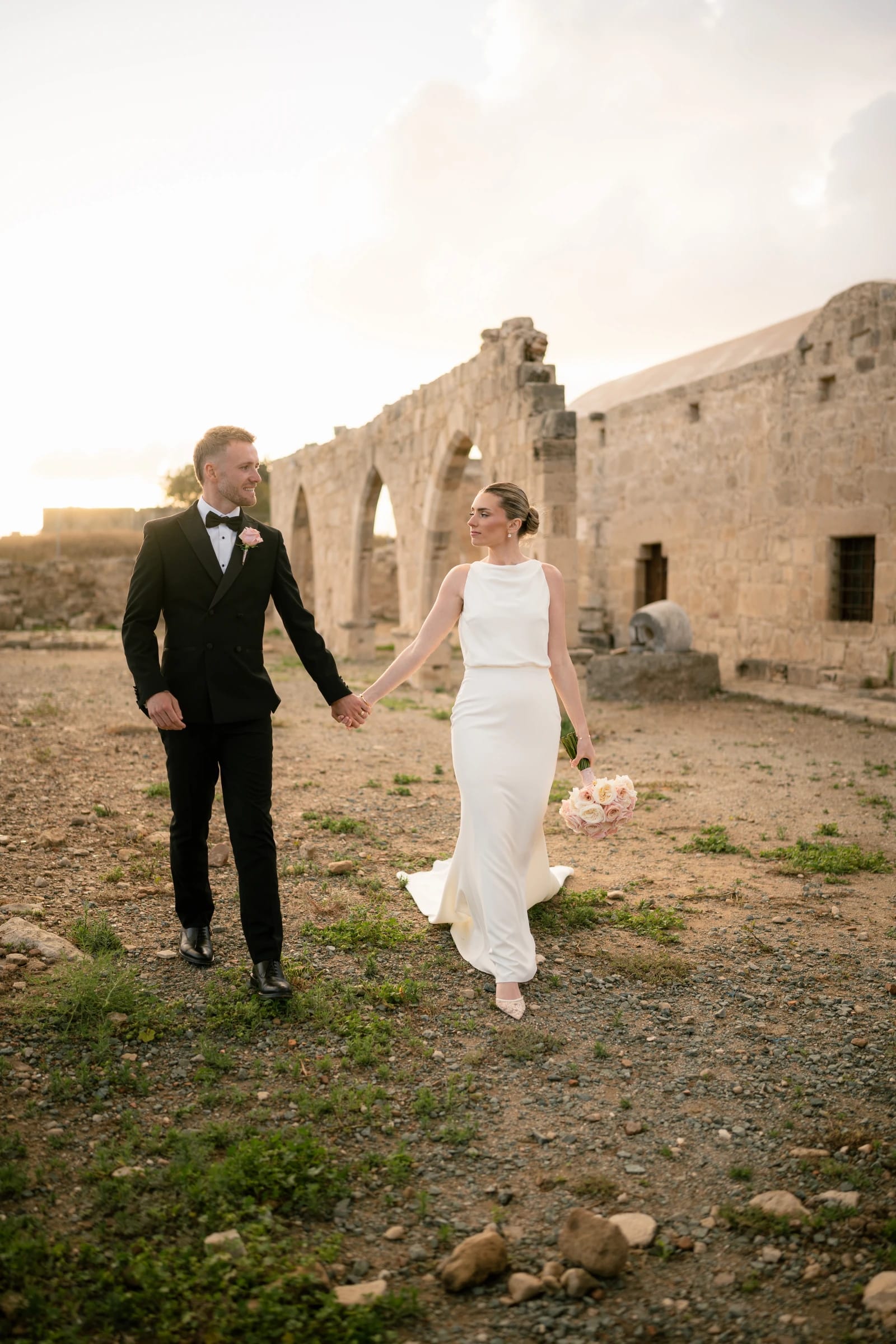 Daniel and Bailey walking hand in hand through the stone ruins at Liopetro at sunset, Kouklia, Paphos.