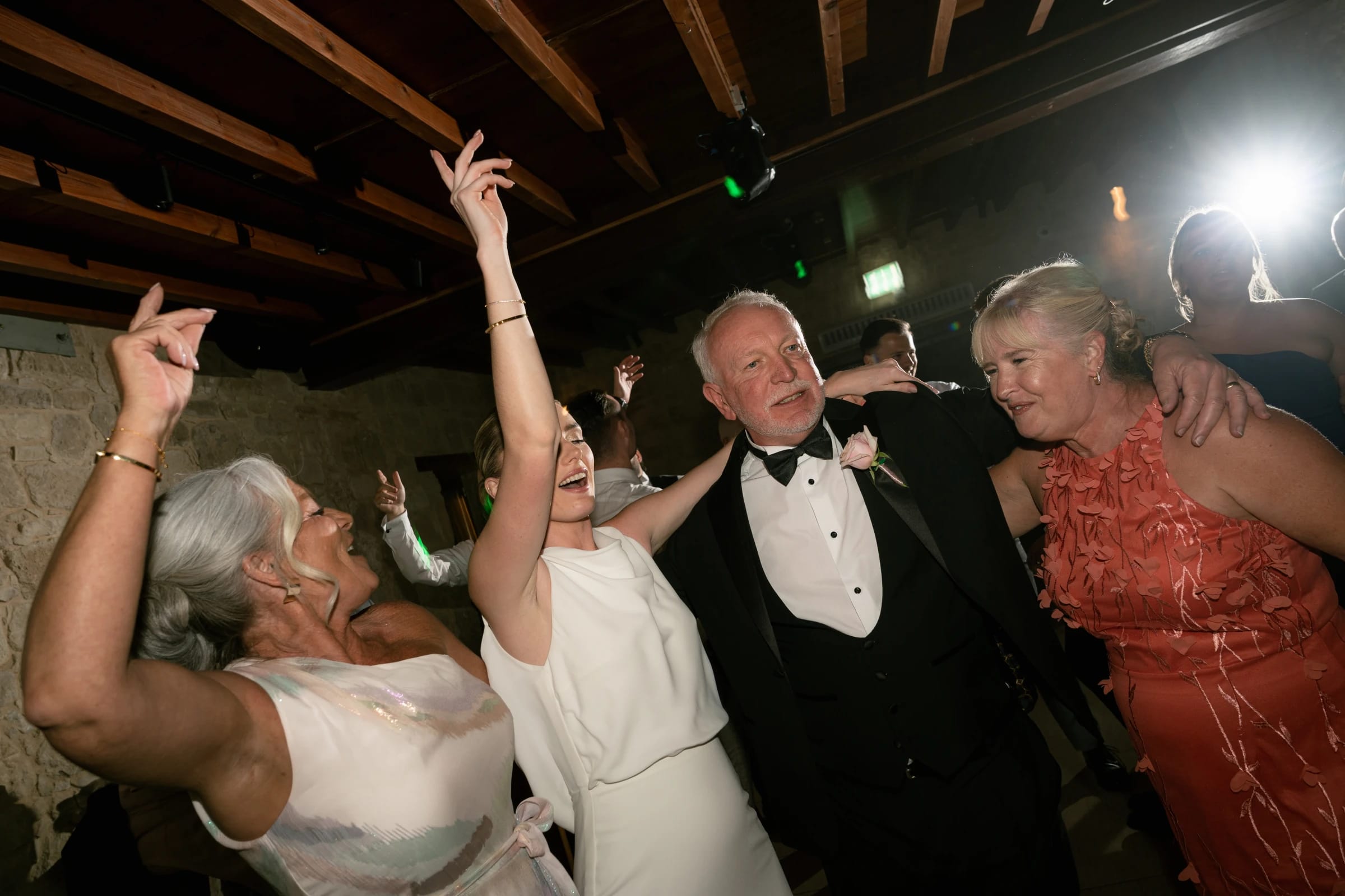 Family and guests dancing with arms raised on the Liopetro dance floor, Paphos, Cyprus.