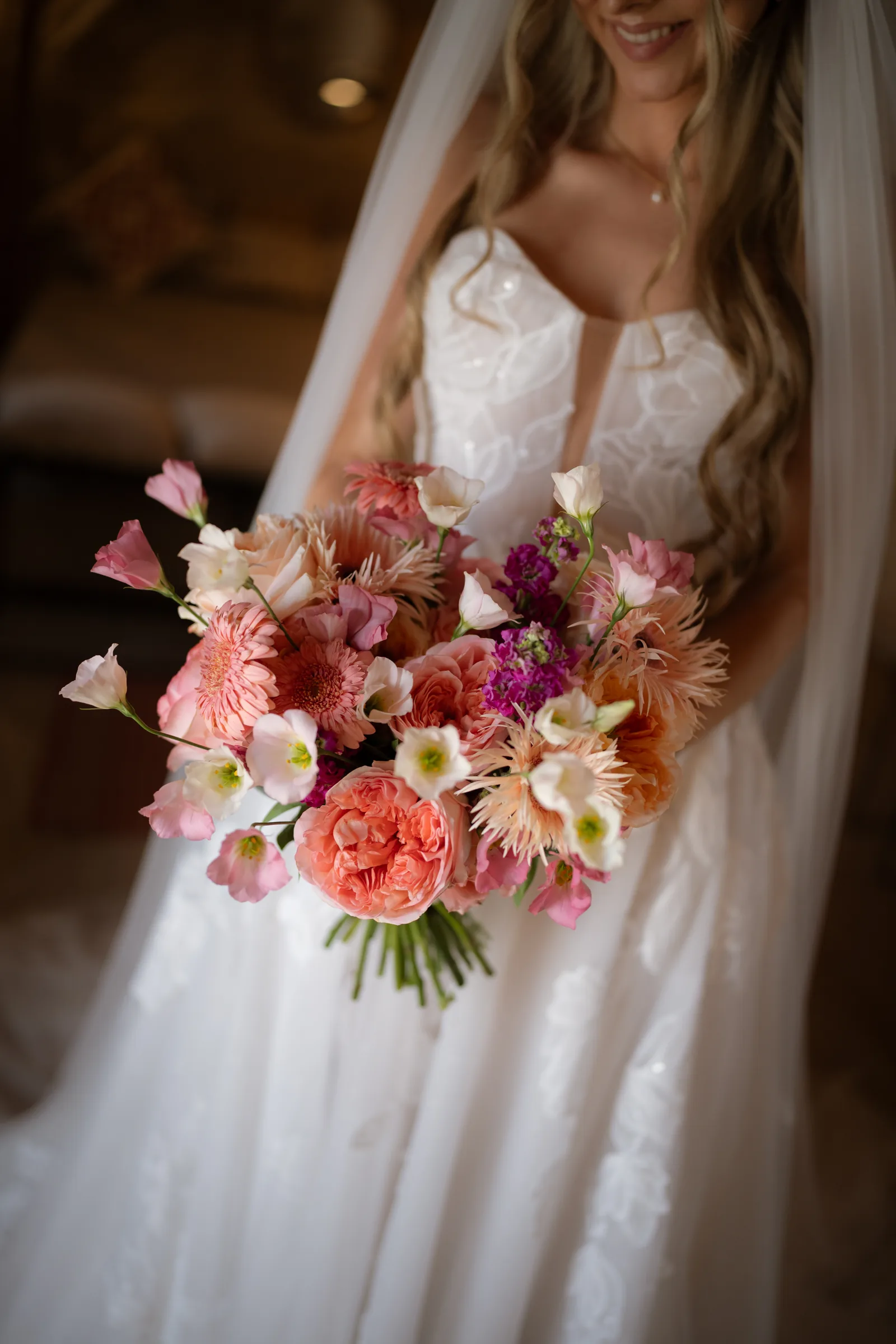 Detail of Franziska's coral, peach and magenta bouquet held against her floral-lace gown at Liopetro, Kouklia, Paphos.
