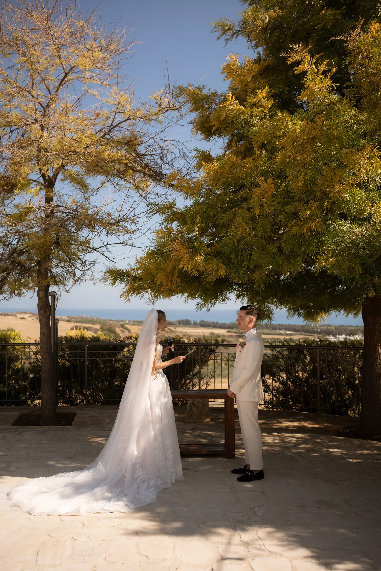 Frank and Franziska together before the ceremony with the Paphos countryside and wind turbines behind them at Liopetro.