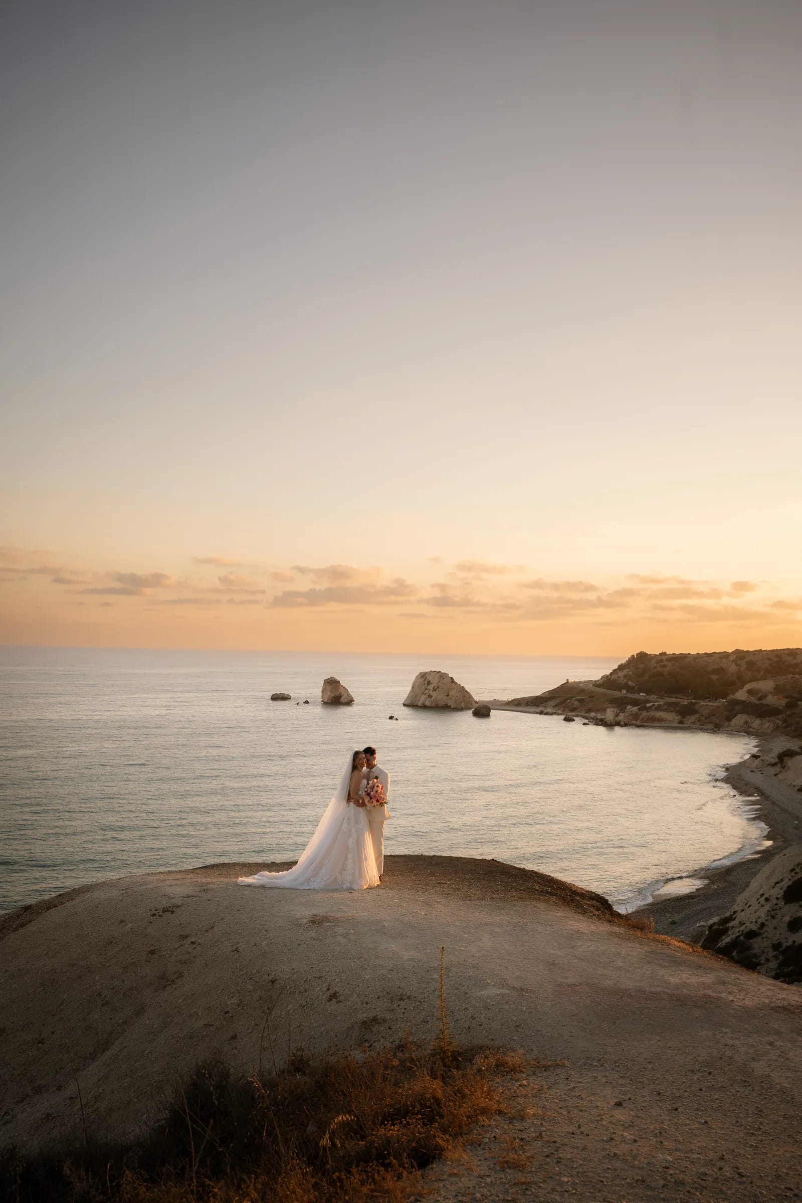 Frank and Franziska on the headland at Aphrodite's Rock as the sun sets over the sea near Paphos, Cyprus.