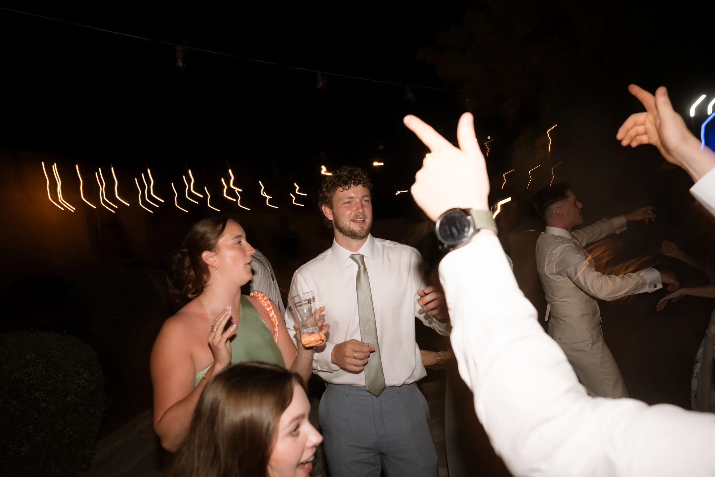 Guests dancing under the festoon lights after dark at the Liopetro wedding reception, Kouklia, Paphos.
