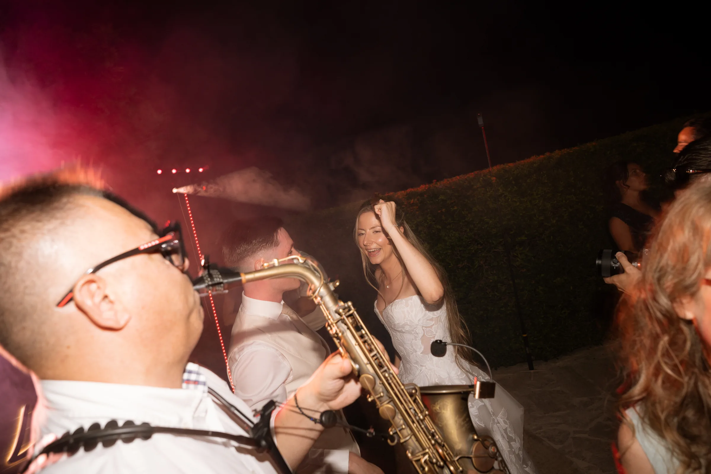 A live saxophonist playing beside Franziska on the dance floor through the smoke and lights at Liopetro, Paphos.