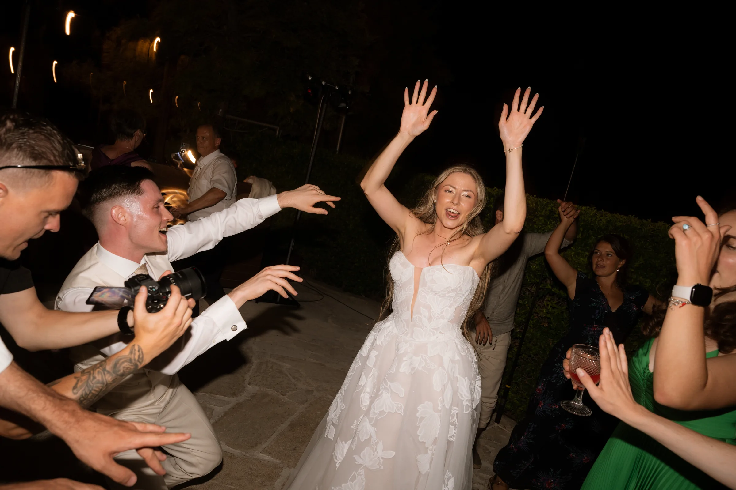 Franziska dancing with arms raised surrounded by guests at the Liopetro wedding reception, Kouklia, Paphos.