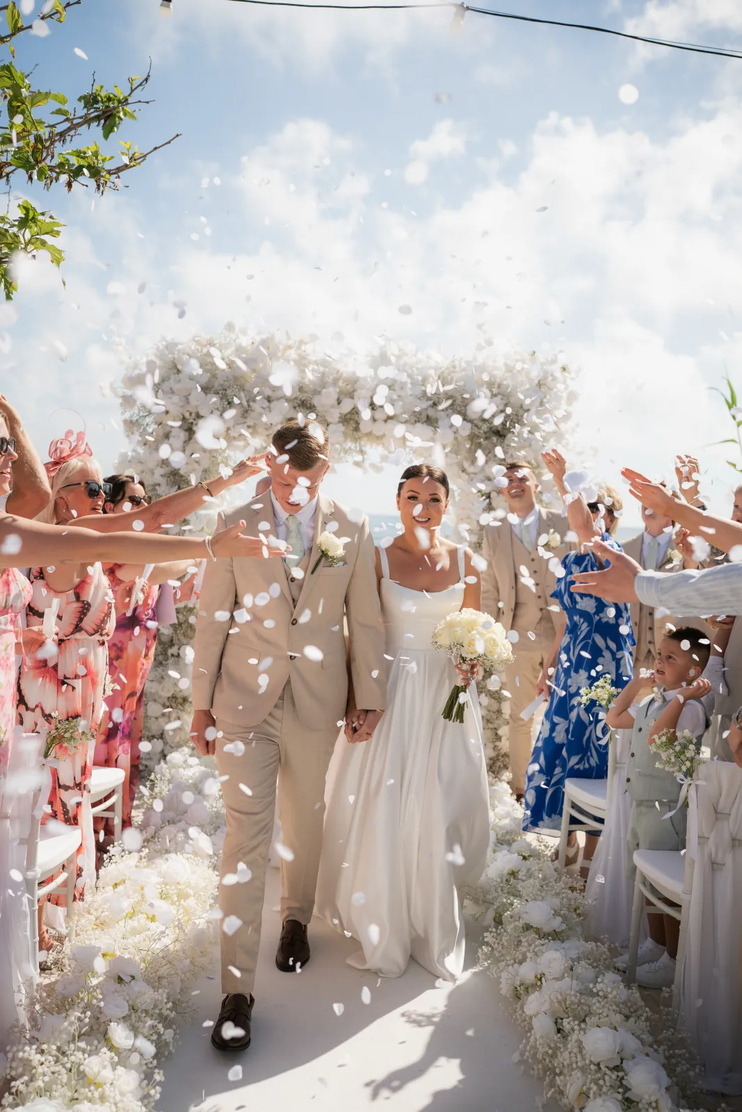 Confetti falling as Sian and Aaron walk back up the aisle after their ceremony at Coral Residences, Paphos, Cyprus.